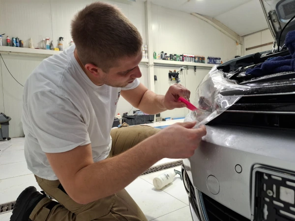 Miloš Marković, vlasnik LaserWash Rumenka, pri lepljenju PPF folije na far VW Golf 6 u detailing centru kod Novog Sada