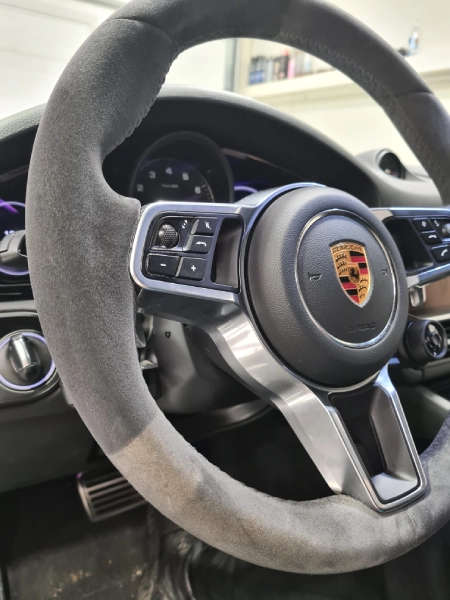 Porsche alcantara volan tokom čišćenja u LaserWash Rumenka — vidljiva razlika između očišćenog i neočišćenog dela volana